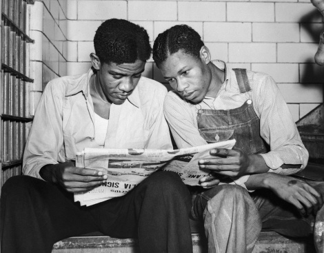 Charles Weems and Clarence Norris, two of the Scottsboro Boys, read a newspaper in their Alabama jail cell.